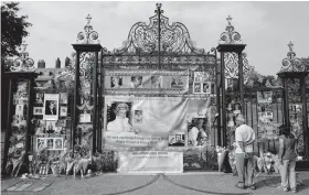  ??  ?? BELOVED PRINCESS Visitors look at photograph­s of Diana, Princess of Wales, and floral tributes left outside Kensington Palace in Central London on Tuesday ( Wednesday in Manila) ahead of the 20th anniversar­y of Princess Diana’s death.