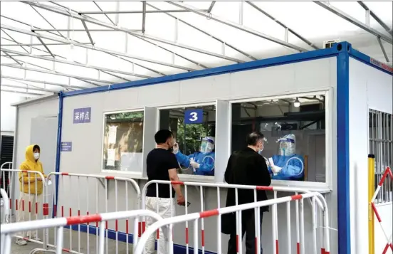  ?? ?? Citizens take nucleic acid tests at a testing site in east China’s Shanghai, April 27, 2022. (Xinhua/Zhang Jiansong)