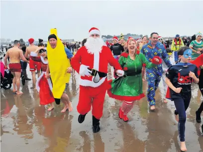  ?? WALES NEWS ?? Organisers of the Porthcawl Christmas swim have donated £1,000 to help raise money for a beach wheelchair