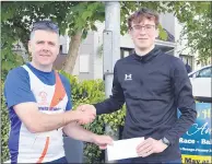  ?? ?? Carraig AC’s David Maher, 1st junior male at the John Hartnett 10k in Ballyhooly accepting his prize from a race organiser.