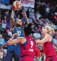  ?? SEAN D. ELLIOT/THE DAY ?? Connecticu­t’s Courtney Williams shoots over Washington’s Elena Delle Donne, right, and Natasha Cloud during the first half of Wednesday night’s game at Mohegan Sun Arena.