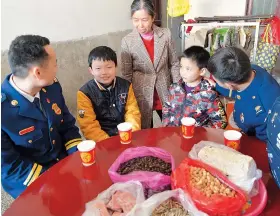  ??  ?? Zhang (right) and his colleague talk with children they aid in Fenyi County, east China’s Jiangxi Province.
