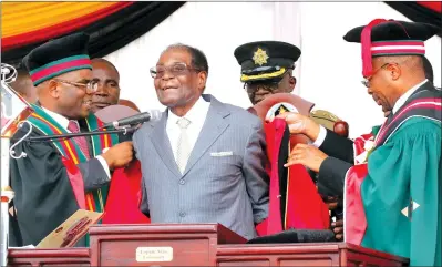 ?? — (Picture by Eliah Saushoma) ?? Lupane State University yesterday conferred a Doctorate in Agricultur­al Science on President Mugabe. Assisting the President to wear the academic colours are, the Registrar Jairos Makunde (left) and Vice Chancellor Professor Pardon Kuipa.