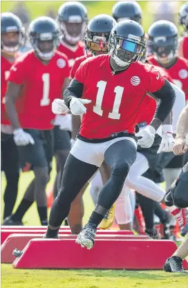  ?? CURTIS COMPTON / CCOMPTON@AJC.COM ?? Falcons wide receiver Julio Jones runs an agility drill on Thursday’s first day of practice at training camp in Flowery Branch. Defensive end and No. 1 draft pick Takkarist McKinley, recovered from surgery, was also on the field.