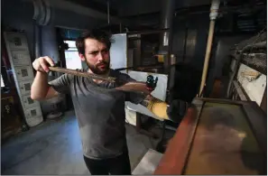  ?? NWA Democrat-Gazette/J.T. WAMPLER ?? Glass blower Micah Welsh puts a Bluebird of Happiness into a finishing oven Thursday at Terra Studios in Durham.