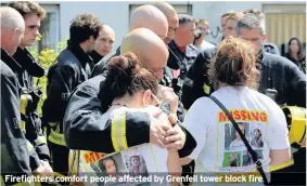  ??  ?? Firefighte­rs comfort people affected by Grenfell tower block fire