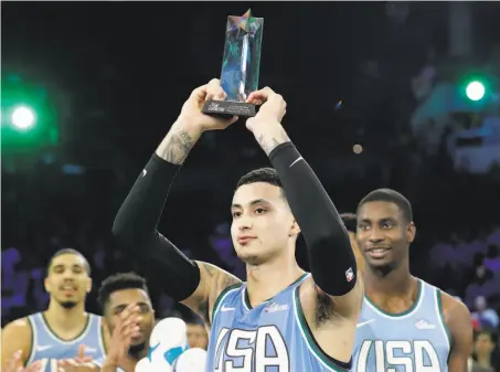  ?? Chuck Burton / Associated Press ?? Lakers forward Kyle Kuzma hoists the MVP hardware after leading the U.S. team to a win over the World team in Charlotte, N.C.