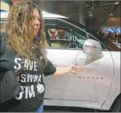  ?? Steve Russell Toronto Star ?? A GENERAL MOTORS worker displays her version of GM, which she calls “Greedy Motors,” in Toronto.