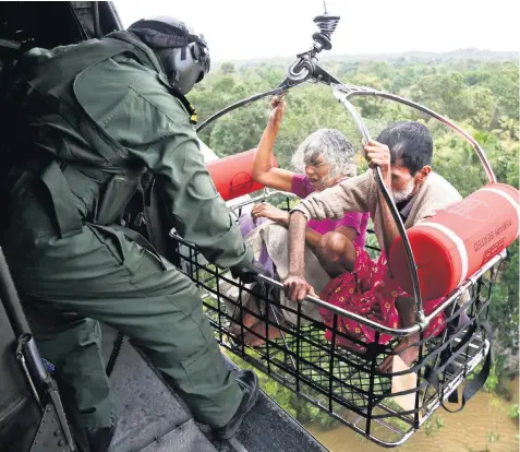  ??  ?? Navy personnel airlift survivors out of flooded areas in the southern state of Kerala as all three wings of India’s armed forces were called on to help rescue efforts