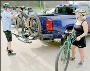  ??  ?? Bella Vista resident Dan McCaherty (left) unloads his bicycle for some greenway riding while talking with Roma McCaherty.