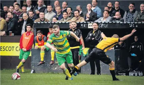  ?? James Eastup ?? Connor McCarthy tries to get away from his Prescot Cables marker under the gaze of the Runcorn Linnets bench during last Saturday’s clash at a packed Volair Park.