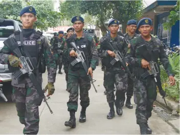  ?? SUNSTAR FOTO/ ALEX BADAYOS ?? ON THE GROUND. At least 42 additional police officers are now in Talisay, but focused on one barangay. Tangke’s officials requested their presence there.