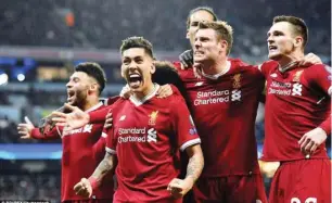  ??  ?? Roberto Firmino and his Liverpool team-mates celebrate in front of the away fans as they secure a semi-final berth yesterday