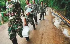  ?? Reuters ?? Men carry provisions near the Tham Luang cave complex in Thailand, where the rescue operation is ongoing.