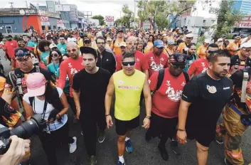  ??  ?? BIEN ACOMPAÑADO. Decenas de personas lo escoltaron en el inicio de la marcha en Hato Rey. Al lado de Raymond Arrieta estuvo el cantante Jeancarlos Canela, con gorra y ropa oscura, y a su derecha Abrante, del grupo musical la Tribu de Abrante.