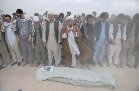  ?? SHAH MARAI / AFP / GETTY IMAGES ?? Afghan mourners offer funeral prayers for one of the 80 victims killed in Saturday’s suicide attack in Kabul. The attack, which was claimed by the Islamic State group, was the first by ISIL on the Afghan capital, raising concerns about the group’s...