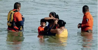  ?? Reuters ?? Migrants refuse help from members of the Mexican immigrant welfare agency Grupo Beta to go back to land as they wait to be rescued by a US border patrol boat during their attempt to cross the Rio Bravo towards the US, as seen from Piedras Negras, Mexico. —