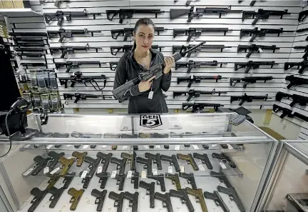  ?? PHOTO: AP ?? Gun shop owner Tiffany Teasdale-Causer poses for a photo with a Ruger AR-15 semi-automatic rifle - a weapon similar to that used in the Parkland, Florida, shooting.