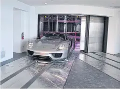  ??  ?? A Porsche arrives in a condo in the automated car elevator in the Porsche Design Tower.
