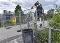  ?? JOHN RENNISON, THE HAMILTON SPECTATOR ?? Two men climb around and over the barricade at the Bayfront Park end of the Waterfront Trail on Saturday.