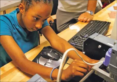  ?? STEVEN SENNE/ AP PHOTO ?? Makeda Stephenson, 13, works on a component for a flight simulator at an MIT Fabricatio­n Labs program in Boston.