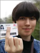  ?? PHOTO/CARRIE ANTLFINGER ?? In this April 28 photo, Catelin Tindall holds her expired student ID from the Milwaukee Institute of Art and Design at Cannon Park in front of the building where she tried to vote during the November 2016 presidenti­al election. AP