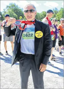  ?? BETH PENNEY/THE TELEGRAM ?? Joe Ryan was dressed with style — full tuxedo and running shoes — Sunday as he competed in his 45th Tely 10.