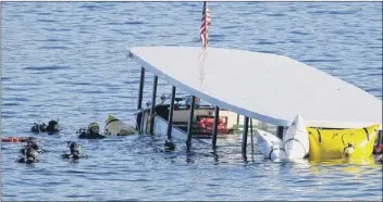  ?? Times Union archive photos ?? Above left, the Ethan Allen moves out into the center of Lake George in Warren County on a floating classroom tour of the lake on July 20, 2005. Above right, divers, at left, are seen near the Ethan Allen on Oct. 3, 2005, a day after it sank in Lake George. Like the limousine involved in October’s deadly crash in Schoharie County, the Ethan Allen was subject to state inspection­s.