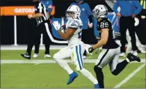  ?? PHOTO BY CHRIS UNGER — GETTY IMAGES ?? Indianapol­is Colts running back Jonathan Taylor runs for a 62-yard touchdown against the Las Vegas Raiders in the second half of their game on Sunday in Las Vegas.