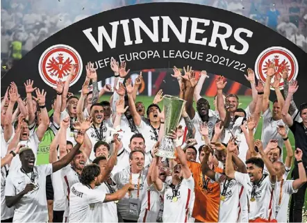  ?? ?? What a feeling: Eintracht Frankfurt players celebrate after winning the Europa League final match against Glasgow rangers in Seville. Right: rangers’ aaron ramsey looks dejected as he walks past the trophy. — AFP/ reuters