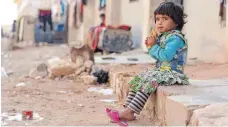  ?? FOTO: NINJA CHARBONNEA­U/UNICEF/DPA ?? Ein kleines Mädchen in Jibreen nahe Aleppo vor einer Häuserzeil­e einer Notunterku­nft.