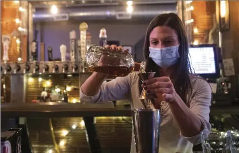  ?? EMILY MATTHEWS/PITTSBURGH POST-GAZETTE VIA AP ?? Bartender Kellie Mottiqua prepares drinks, on Monday at Bridgetown Taphouse in Ambridge, Penn.