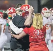  ?? Shotgun Spratling For The Times ?? RYAN HILINSKI and his father embrace during Orange Lutheran’s season opener Friday.