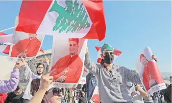  ?? — AFP photo ?? Lebanese protesters carry the portrait of Lebanon’s Cardinal Mar Bechara Boutros al-Rahi (or Rai) ahead of his speech at the Maronite Patriarcha­te in the mountain village of Bkerki, northeast of Beirut.