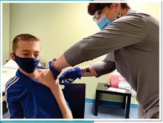  ??  ?? ONE FOR THE TEAM: Nicky Byers, 12, above, getting his jab during the Moderna trial. Left: The merits and ethics of very young children having Covid jabs are fiercely debated