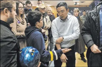  ?? Sara Burnett The Associated Press ?? Democratic presidenti­al candidate Andrew Yang gets ready to bowl Monday after a campaign event in Clinton, Iowa. Yang raised over $16 million in the fourth quarter.
