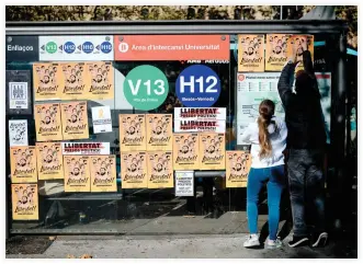  ??  ?? Pro-independen­ce demonstrat­ors stick posters demanding freedom for imprisoned politician­s and leaders of separatist movements during a demonstrat­ion called by students at the University of Barcelona, in Spain on Sunday. (AFP)