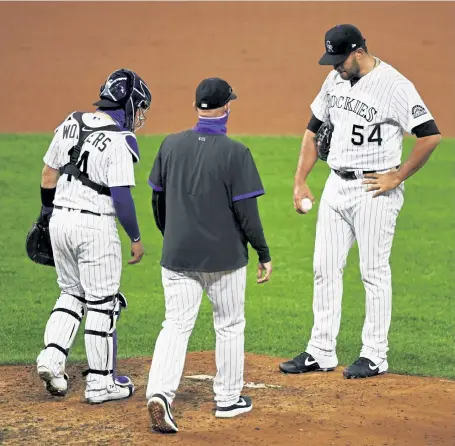  ?? Andy Cross, The Denver Post ?? Rockies catcher Tony Wolters and pitching coach Steve Foster come to the mound to talk with relief pitcher Carlos Estevez after he threw a wild pitch last week.