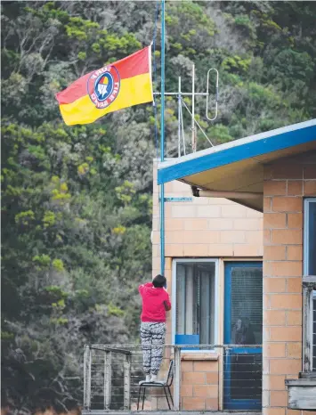  ?? Picture: ANDREW HENSHAW ?? TOWN IN MOURNING: The flag at Port Campbell SLSC flies at half mast after two members from the club drowned on Sunday.