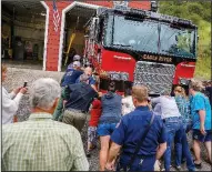  ?? AP/Vail Daily/CHRIS DILLMANN ?? Residents help push the Eagle River Fire Protection District’s new engine into service Wednesday in Minturn, Colo., a tradition that hearkens to when firefighti­ng vehicles had to be pushed back into the station by hand.