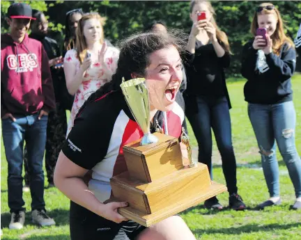  ?? TYLER DAWSON/OTTAWA CITIZEN ?? Katia Maxwell-Campagna of the Gloucester High School Gators celebrates after receiving the first-place trophy in the NCSSAA Senior Girls Tier 2 Rugby Championsh­ips on Tuesday. Parents of the players say the dangers of concussion­s were always in their...