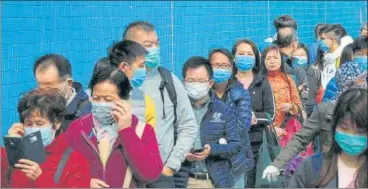  ?? REUTERS ?? Customers queue to buy face masks to prevent an outbreak of a new coronaviru­s in Hong Kong.