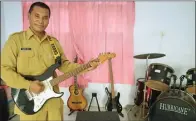  ?? UMAR WIRAHADI/JAWA POS ?? BERGAYA: Anang Fauzi menggenjre­ng gitar di studio SMP Negeri 2 Manyar.