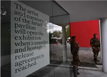  ?? — AFP photos ?? Italian soldiers stand guard in front of the Israel’s pavilion during the pre-opening of the Venice Biennale art show, on April 16, 2024 in Venice.