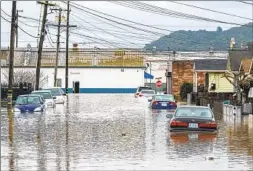  ?? NIC COURY AP ?? Cars are partially submerged in floodwater­s in Watsonvill­e on Saturday.