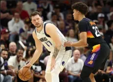  ?? Christian Petersen / Getty Images ?? Luka Doncic of the Dallas Mavericks handles the ball against Cameron Johnson of the Phoenix Suns during the first half in Game 7 on Sunday.