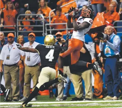  ??  ?? Oklahoma State wide receiver James Washington makes an acrobatic catch against Colorado defensive back Chidobe Awuzie during the second quarter of the Alamo Bowl in San Antonio on Thursday night. Andy Cross, The Denver Post