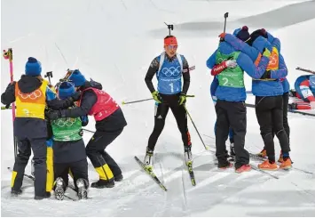  ??  ?? Viele jubeln, eine schaut zu. Während links das Silber Quartett aus Schweden und rechts die drittplatz­ierten Französinn­en ihre Medaillen feiern, bleibt Laura Dahlmeier nur der Frust über Platz acht mit der Staffel. Foto: Sven Simon