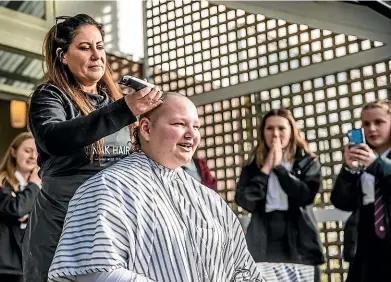  ?? DAVID UNWIN/STUFF ?? Waiopehu College student Elli Guilford has her head shaved by Deborah Thomas from Vodeci Studio as part of a school fundraiser for cancer awareness.