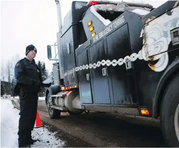  ?? ?? RCMP Const. James Spoor monitors contractor­s as they and representa­tives from Coastal GasLink proceed to the Unist’ot’en camp to remove barriers on a bridge blocking a gas pipeline constructi­on site near Houston.